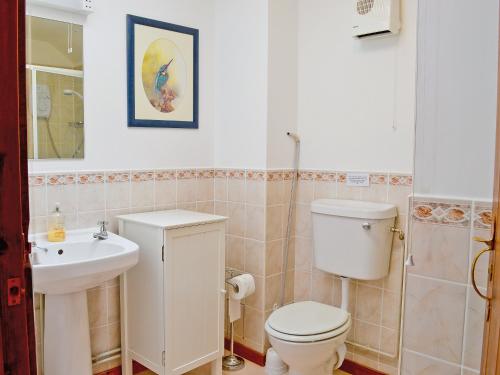 a bathroom with a toilet and a sink at Herons View - 28279 in Brundall