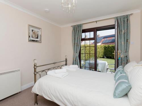 a bedroom with a bed and a large window at Cleets Retreat in Seahouses