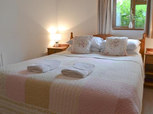 a bedroom with a large bed with two towels on it at Stables-23893 in Aylmerton