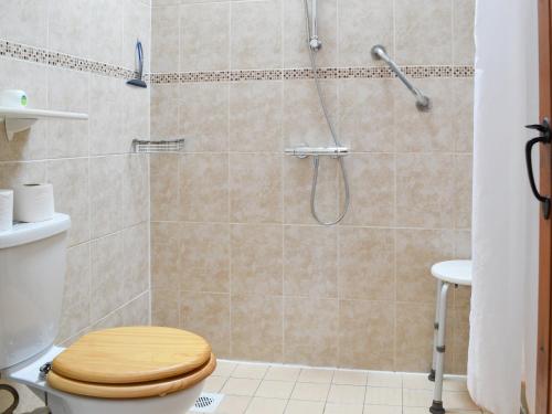 a shower with a wooden toilet in a bathroom at Stables-23893 in Aylmerton