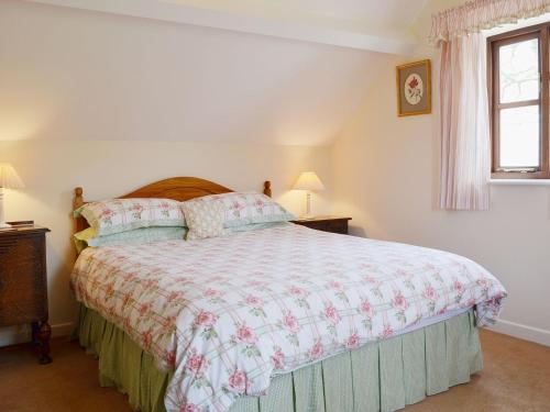 a bedroom with a large bed and a window at Strawberry Cottage in Kinlet