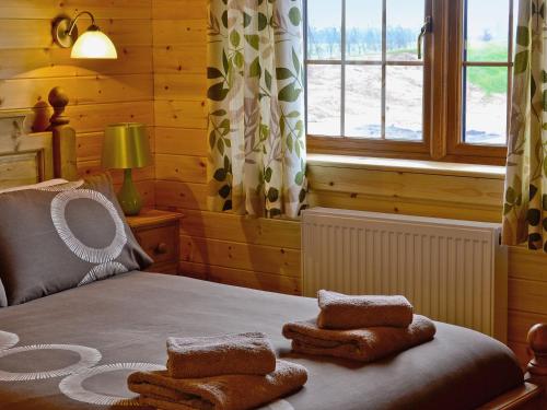 een slaapkamer met een bed met handdoeken erop bij No, 6 Lake View Lodges - 28283 in Leake Common Side