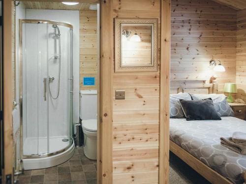 a bedroom with a shower and a bed and a toilet at No, 6 Lake View Lodges - 28283 in Leake Common Side