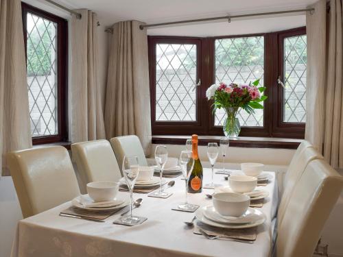 a table with white chairs and a vase of flowers at Sea Breeze in The Mumbles