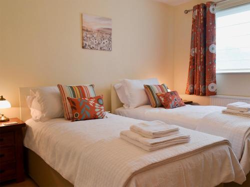 two beds sitting next to each other in a bedroom at Tegfan in Llangenny