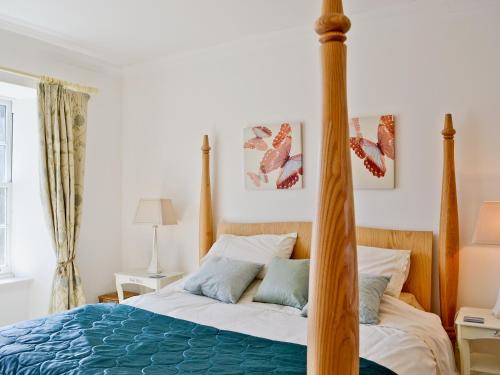 um quarto com uma cama com um poste de madeira em Meadowsweet em Newburgh