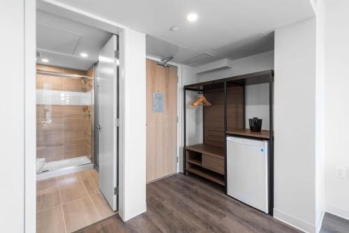 a bathroom with a walk in shower and a refrigerator at YWCA Hotel Vancouver in Vancouver