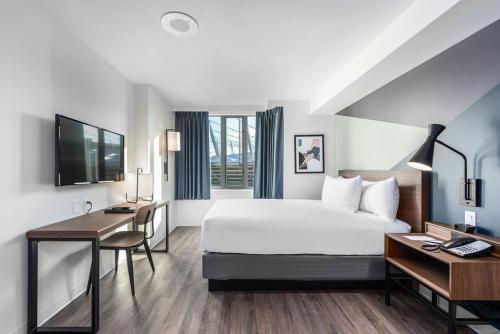 una camera d'albergo con un grande letto e una scrivania di YWCA Hotel Vancouver a Vancouver