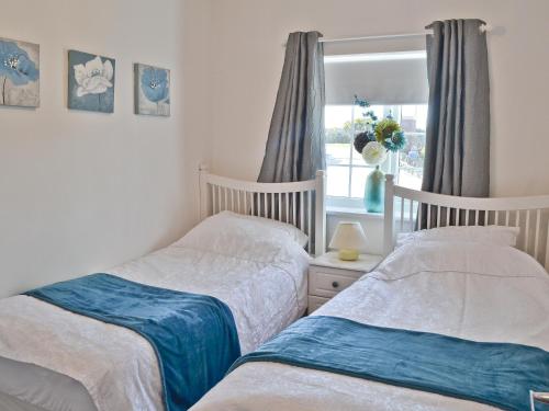 two twin beds in a bedroom with a window at The Snug in Valley