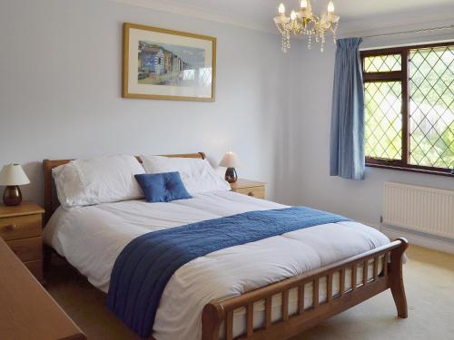 a bedroom with a large bed with a blue blanket at Gearys in Freshwater