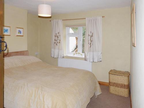 a bedroom with a bed and a window at The Briars in Lydbrook