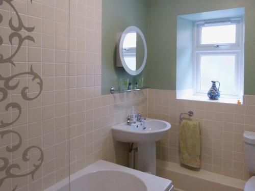 a bathroom with a sink and a toilet and a mirror at The Briars in Lydbrook