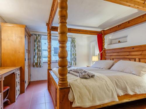 a bedroom with a large wooden bed in a room at Laity in Polperro