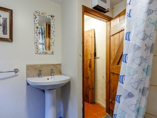 ein Bad mit einem Waschbecken und einem Spiegel in der Unterkunft Laity in Polperro