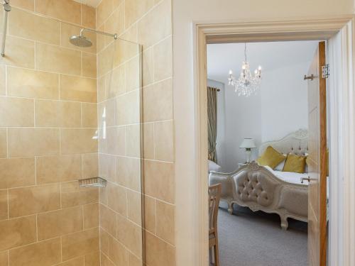 a bathroom with a shower and a bedroom at The Downs in Torquay