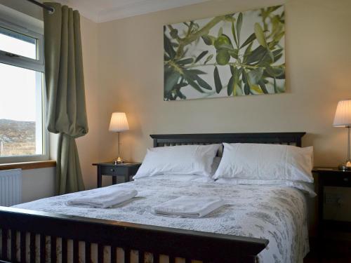 1 dormitorio con 1 cama con 2 toallas en Riverview Cottage, en Acharacle