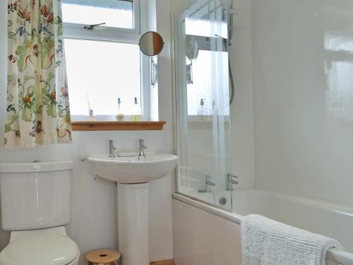 y baño con lavabo, aseo y ducha. en Riverview Cottage, en Acharacle