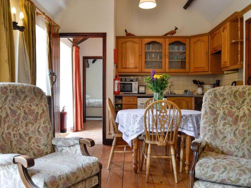 a kitchen with a table and chairs in a kitchen at Daisy Cottage in Chipping Sodbury