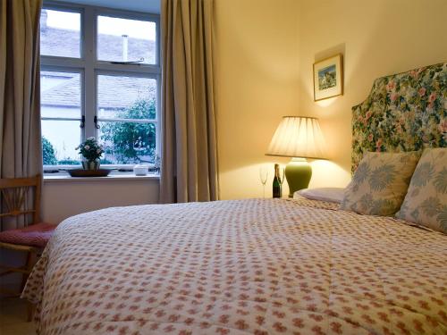 a bedroom with a large bed with a window at Apple Cottage in Forgandenny