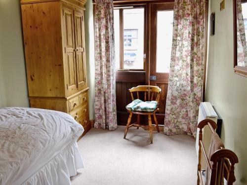 a bedroom with a bed and a chair and a window at Swallows Nest - E3245 in Crackenthorpe