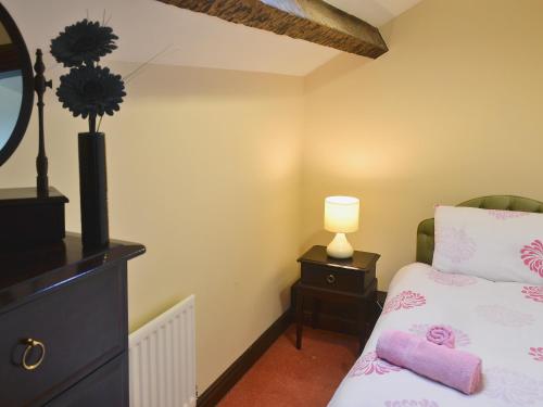 ホークスヘッドにあるSunny Brow Cottageのベッドルーム1室(ベッド1台、ドレッサーのランプ付)