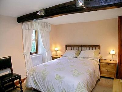 a bedroom with a large bed and a window at The Peat House in Soutergate