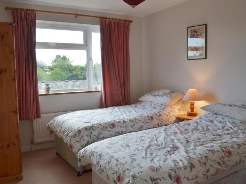 a bedroom with two beds next to a window at Garden View in Brixham