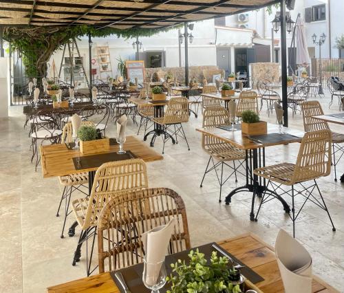 un restaurante con mesas de madera y sillas en una habitación en Hôtel Restaurant La Caravelle, en Sari Solenzara