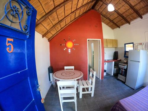 a kitchen with a table and chairs and a refrigerator at Cabañas Giramundos in Punta Del Diablo