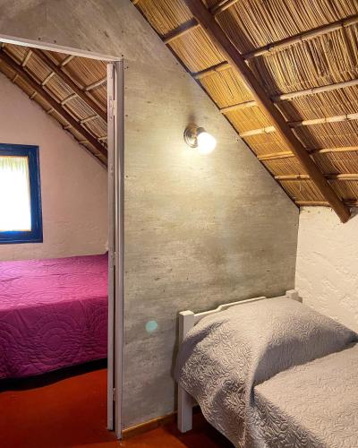 a bedroom with two beds and a window at Cabañas Giramundos in Punta Del Diablo