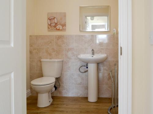 a bathroom with a toilet and a sink at Hazel Cottage in Shotton
