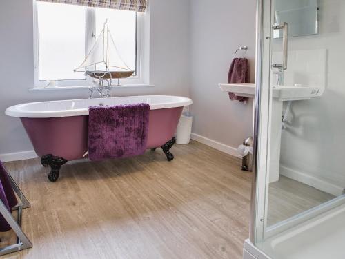 a bathroom with a bath tub with a boat on the window at Lodge Farmhouse in Scarborough