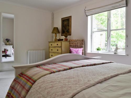 a bedroom with a large bed and a window at The Downs Barn Lodge in Nailsworth