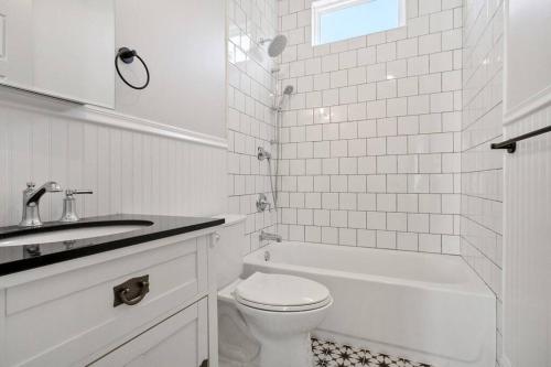 La salle de bains blanche est pourvue de toilettes et d'un lavabo. dans l'établissement Large Orleans Villa, à La Nouvelle-Orléans