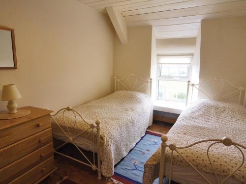 1 dormitorio con 2 camas y ventana en Riffli - Hw7700, en Abersoch