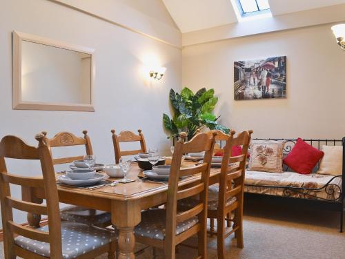 a dining room with a table and chairs and a couch at Piglets Place - E4300 in Halston