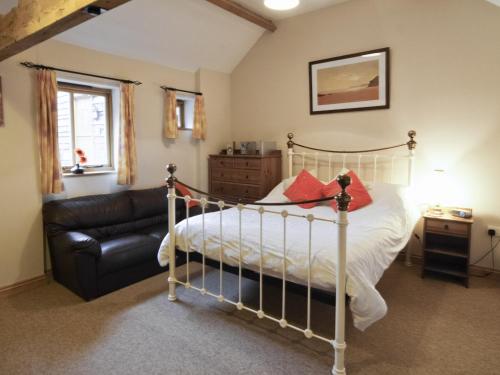 a bedroom with a bed and a leather couch at Piglets Place - E4300 in Halston