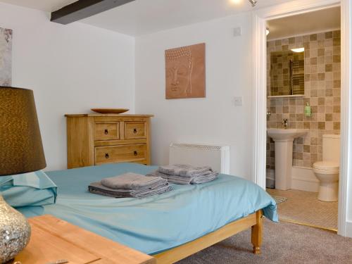 ein Schlafzimmer mit einem Bett und ein Badezimmer mit einem Waschbecken in der Unterkunft Pendref in Trawsfynydd