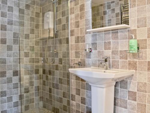 ein Bad mit einem Waschbecken und einer Dusche in der Unterkunft Pendref in Trawsfynydd