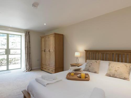 - une chambre avec un grand lit blanc et une tête de lit en bois dans l'établissement Property 1, à Wroxall