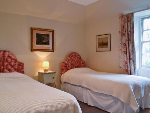 a bedroom with two beds and a window at Old Inzievar in Blairhall