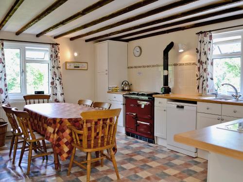 a kitchen with a table and chairs in a room at Maes-yr-adwy in Abergorlech