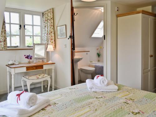 a bedroom with two towels on a bed at Peartree Cottage in Northlew