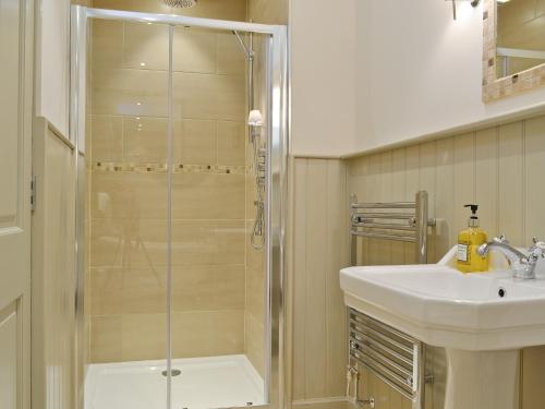 a bathroom with a shower and a sink at Curlew Cottage in Meigle