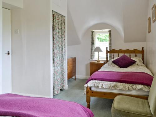 Schlafzimmer mit einem Bett und einem Fenster in der Unterkunft Rose Cottage in Chipping Campden