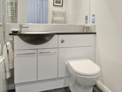 a white bathroom with a sink and a toilet at Bowness Oaks in Bowness-on-Windermere