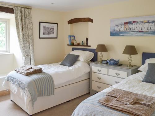 a bedroom with two beds and a dresser at Brow View Cottage in Ravenstonedale