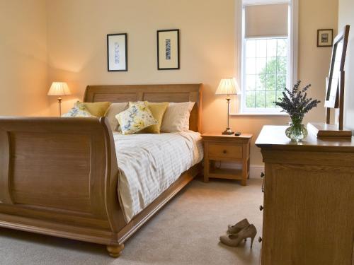 um quarto com uma cama, 2 candeeiros e uma cómoda em Tudor House em Eastrington