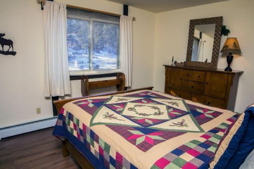 um quarto com uma cama com uma colcha em Elkhorn One Bedroom Condo with River View from Deck and Walking Distance to Estes Park - #3262 em Estes Park