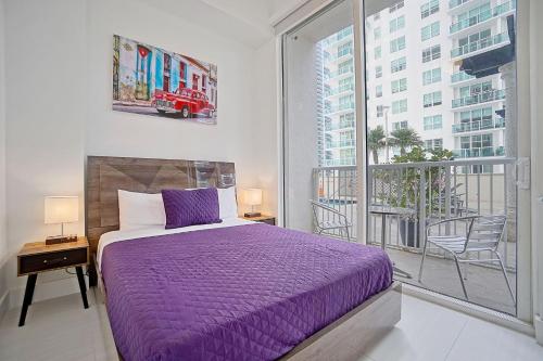 um quarto com uma cama roxa e uma grande janela em Miami Brickell 4 Bedrooms High Ceiling loft on the pool em Miami